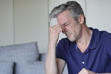 Mature man with bad headache at home
