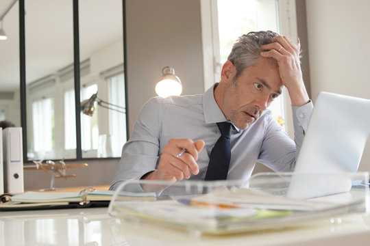 Stressed businessman working in contemporary office