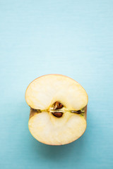 Cut apple (half of apple) on the light blue background, flat lay
