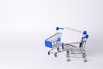 Empty miniature trolley from a supermarket on a white background.