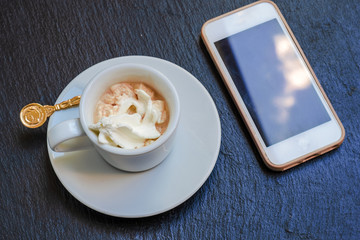 Italian espresso and mobile phone on the slate platter