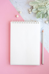 blank notepad page with pencil and plant on pink and marble background. Minimal flat lay