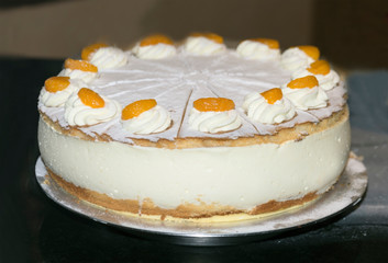 cake with white cream and fruit on a dark background