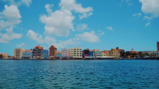 Static wide angle shot looking across the ocean at the stunning world heritage buildings of Willemstad, Curacao, Caribbean