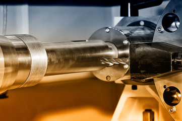 Metal billet is machined on milling machine. Brown toned