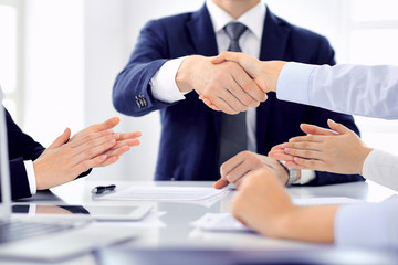 Group of business people or lawyers shaking hands finishing up a meeting , close-up. Success at negotiation and handshake concepts