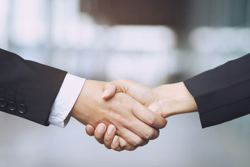Closeup of a businessman hand shake businesswoman between two colleagues  OK, succeed in business...