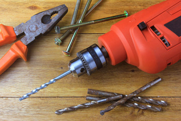 electric drill on carpenter's wood table used in construction and furniture design and repair....