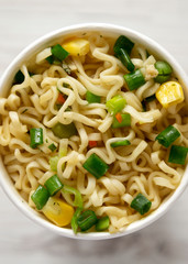 Instant ramen noodles with beef flavoring in a paper cup. Flat lay, from above, overhead. Close-up.
