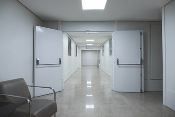 White hospital corridor. Clinic or maternity with white doors stretchers and boards.