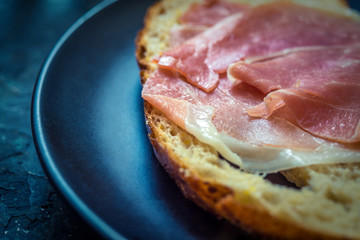 A piece of bread with slice of pork