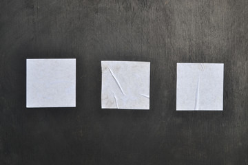 Three white sheets of paper on a black background.