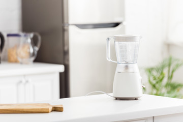 blender near wooden chopping board in modern kitchen