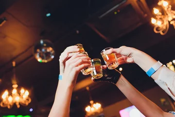 Foto op Plexiglas Hand holding a glass shot with vodka shot. © Евгений Вершинин