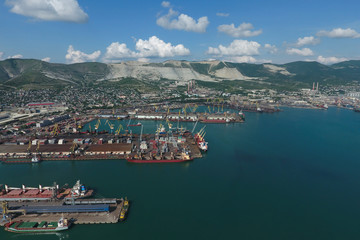 Naklejka premium Port morski przemysłowy, widok z góry. Dźwigi portowe, statki towarowe i barki.