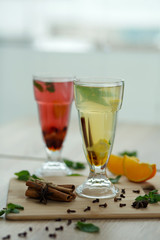 two glasses with colored hot drinks from which steam comes. winter hot seasonal vitemin drinks