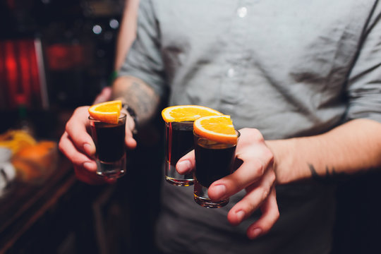 Jagermeister Shots cocktails with orange hand male.