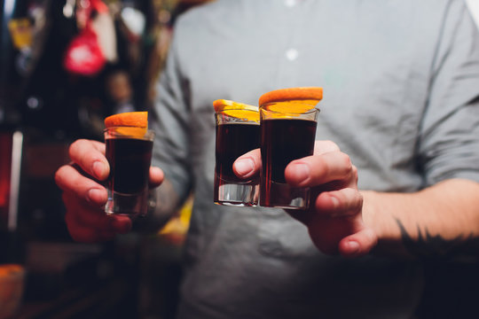 Jagermeister Shots cocktails with orange hand male.