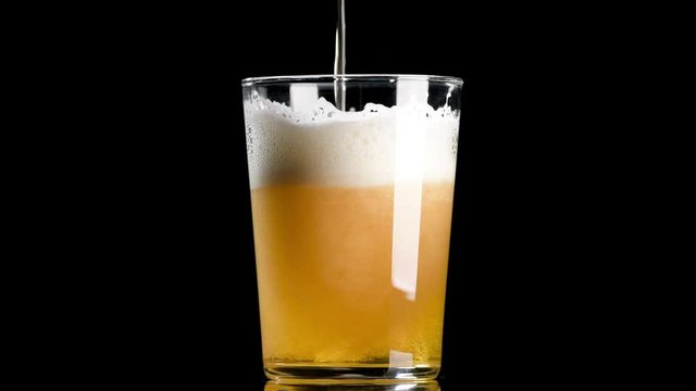 Cerveza cayendo en vaso sobre fondo negro 4k