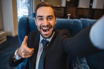 Obraz premium Handsome young excited businessman wearing suit