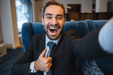 Handsome young excited businessman wearing suit