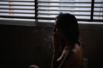 Sexy concept. Sensual women are sucking cigarettes in the toilet. Sexy women are relaxed by sucking cigarettes.