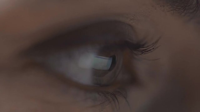 close up view of woman scrolling pages on computer with monitor reflection in eye isolated on grey