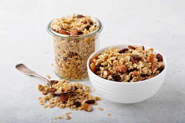 Homemade granola with coconut, raisins and almonds for breakfast in a jar and a bowl