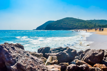 Yarada Beach, Visakhapatnam, India 10 December 2018 - People relaxing and enjoying in Yarada Beach. The Coast area is surrounded by hills and Bay of Bengal with lush green trees and golden soft sands.