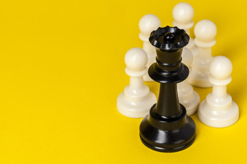 Chess figures on yellow background top view copy space