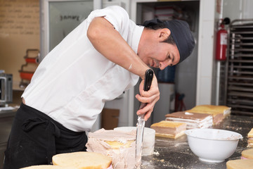 Pastry Chef preparing a cake in the pastry shop kitchen .