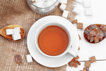 Glass cup of hot tea with sugar on the table