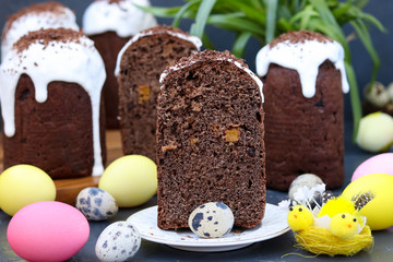 Still life with chocolate Easter cakes and colorful eggs on a dark background