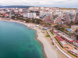Fototapeta na wymiar Aerial view of new modern buildings at sea coastline near sand beach, Gelendzhik city - resort on black sea for summer tourism and vacation