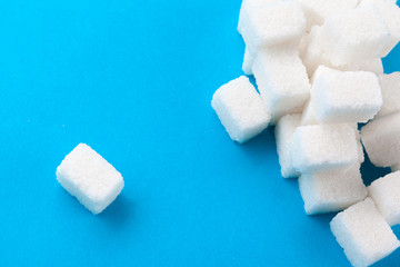 White sugar cubes on a bright blue background