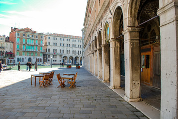 Fototapeta na wymiar Bistro Set on stone square along the main canal in Venice Italy