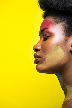 Side view of african american girl with body art isolated on yellow