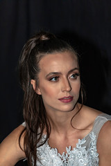 Portrait of a girl with long hair  and green eyes in a wedding dress on a black background