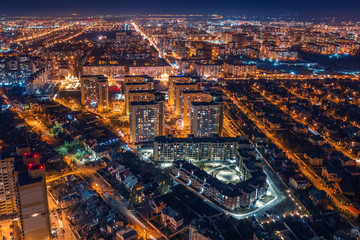 Obraz premium Aerial panoramic view, flight on drone above night city Voronezh with illuminated roads and high-rise buildings