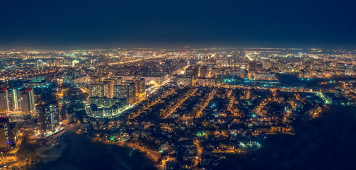 Fototapeta na wymiar Aerial panoramic view, flight on drone above night city Voronezh with illuminated roads and high-rise buildings