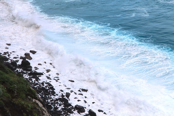 Blue gushing ocean. The waves of the ocean form a lot of white foam. Cropped shot, horizontal, a...