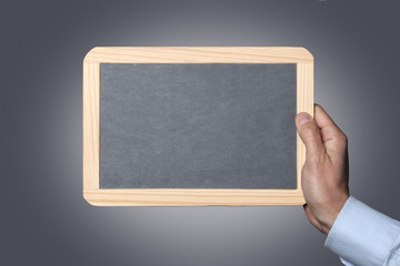 male man showing a chalk blackboard isolated on grey background space for your text