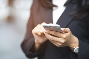 Lifestyle close up hand business women in suits color red looking watching message on mobile smart phone during break. using cell phones to communicate in the online world. working woman.