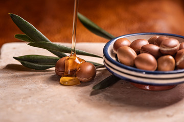 argan oil pouring over argan seeds