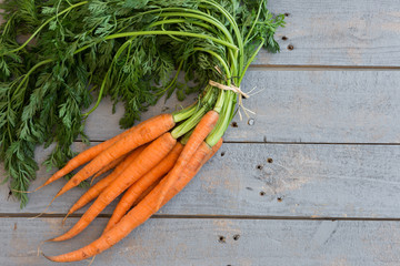 Fresh carrots bunch on wooden background with copy space