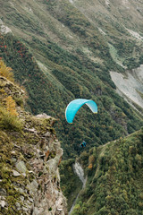 paraglider fly over mountain on a sunny day. Paragliding in the Caucasus Mountains