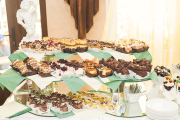 Delicious and tasty dessert table with cupcakes shots at reception closeup