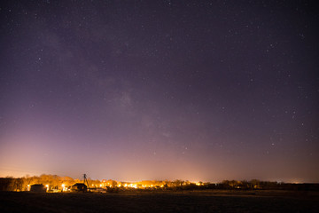 Milky Way over the illuminated small village