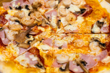 Closed up of seafood pizza on wooden table.