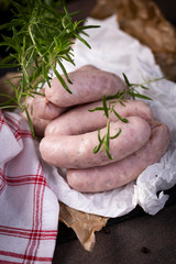 White sausage. Traditional raw white sausage on a wooden background.